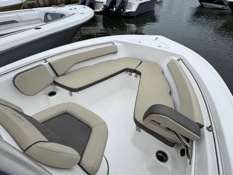 Slide: The Image of 2020 Tidewater 198 CC Adventure boat with beige seating, docked on calm water. - 14