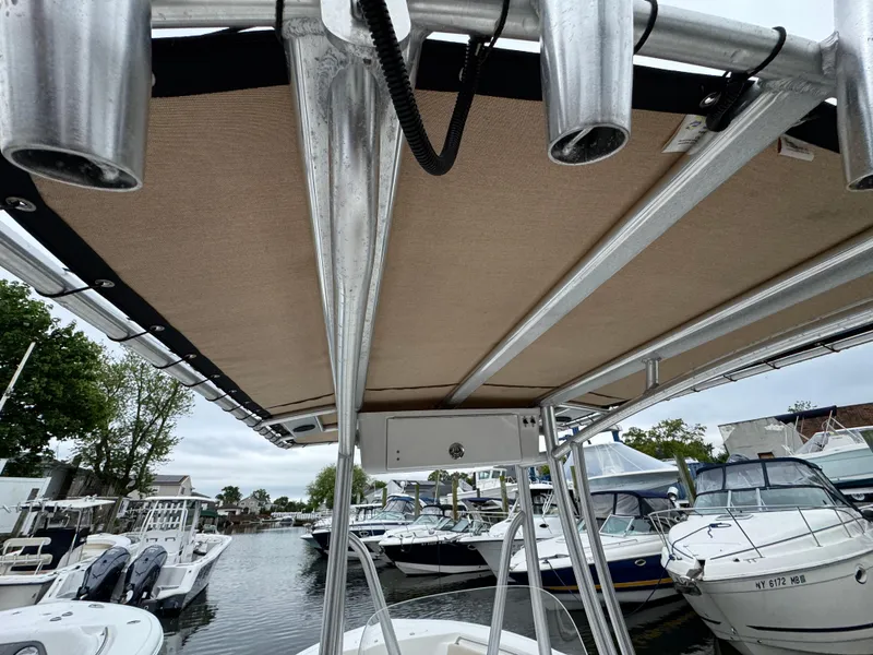 Slide: The Image of 2020 Tidewater 198 CC Adventure boat with T-top, docked among other boats. - 19