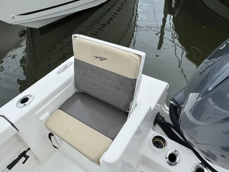 Slide: The Image of 2020 Tidewater 198 CC Adventure boat seat with cup holders and motor, docked on water. - 4