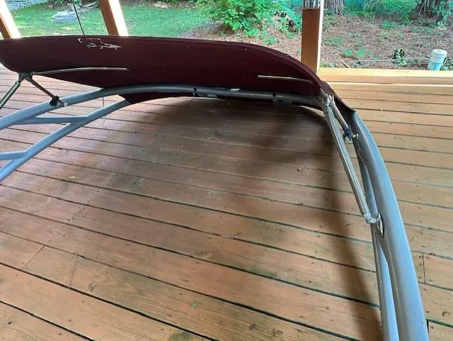 Slide: The Image of 2013 Rinker Captiva 220 MTX bimini top on wooden deck, partially folded. - 13