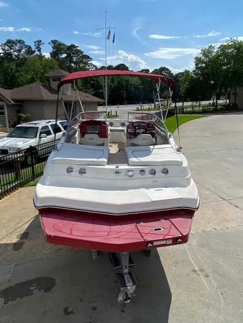 Slide: The Image of 2013 Rinker Captiva 220 MTX boat with red and white design, parked on a driveway. - 3