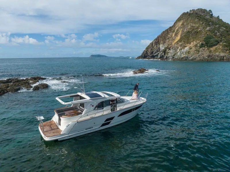Slide: The Image of 2025 Marex 330 Scandinavia yacht cruising near rocky island in clear blue waters. - 13