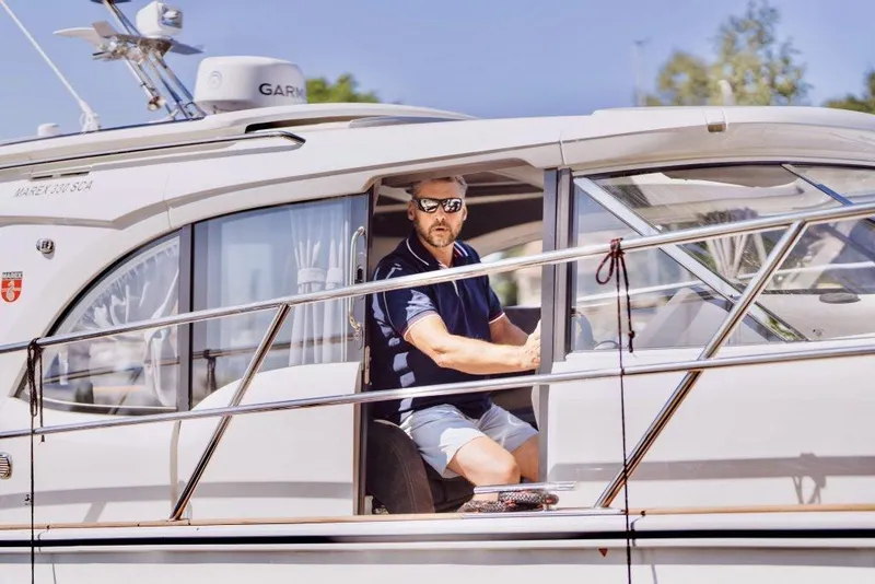 Slide: The Image of Man piloting 2025 Marex 330 Scandinavia boat, wearing sunglasses, in sunny weather. - 28