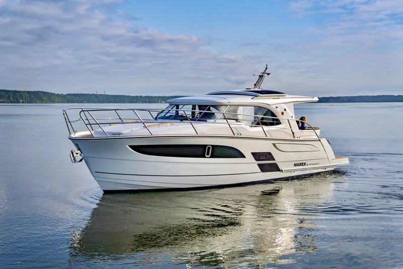 Slide: The Image of 2025 Marex 330 Scandinavia yacht cruising on calm waters under a blue sky. - 41