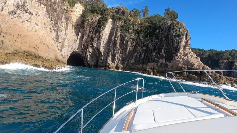 Slide: The Image of Marex 330 Scandinavia boat approaching rocky coastal cave, 2025 model. - 40