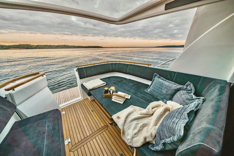 Slide: The Image of Luxurious Marex 330 Scandinavia yacht interior with cozy seating, overlooking serene waters at sunset. - 6