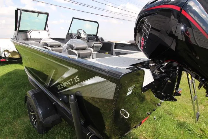 Slide: The Image of 2025 Lund 1875 Impact XS Sport boat with powerful outboard motor on grass. - 1
