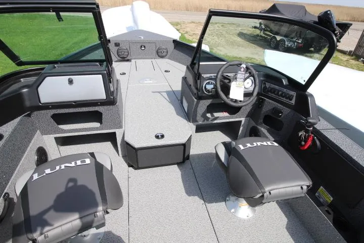 Slide: The Image of 2025 Lund 1875 Impact XS Sport boat interior with seating and steering console. - 3