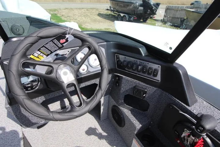 Slide: The Image of 2025 Lund 1875 Impact XS Sport boat dashboard with steering wheel and control panel. - 4