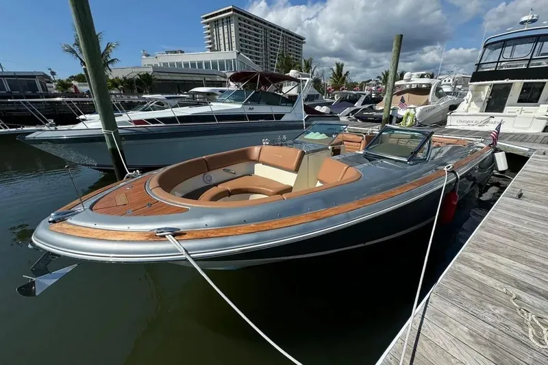 Slide: The Image of 2013 Chris-Craft Launch 32 boat docked at marina under a partly cloudy sky. - 1