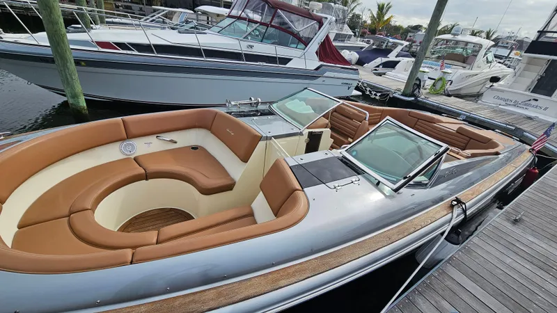 Slide: The Image of 2013 Chris-Craft Launch 32 boat with tan seating, docked at a marina. - 11