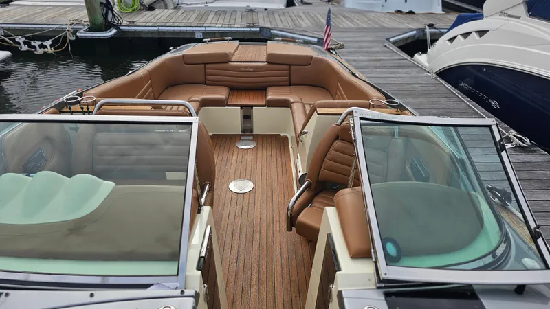 Slide: The Image of 2013 Chris-Craft Launch 32 boat with luxurious brown leather seating and wooden deck. - 13