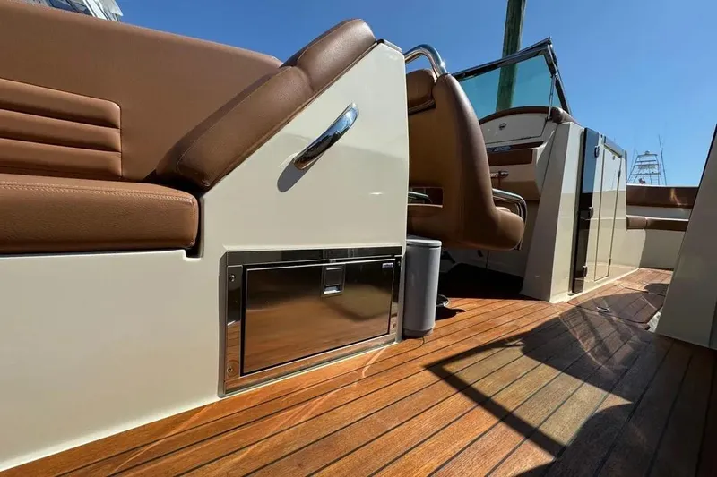 Slide: The Image of 2013 Chris-Craft Launch 32 interior with brown seating and wooden deck. - 15