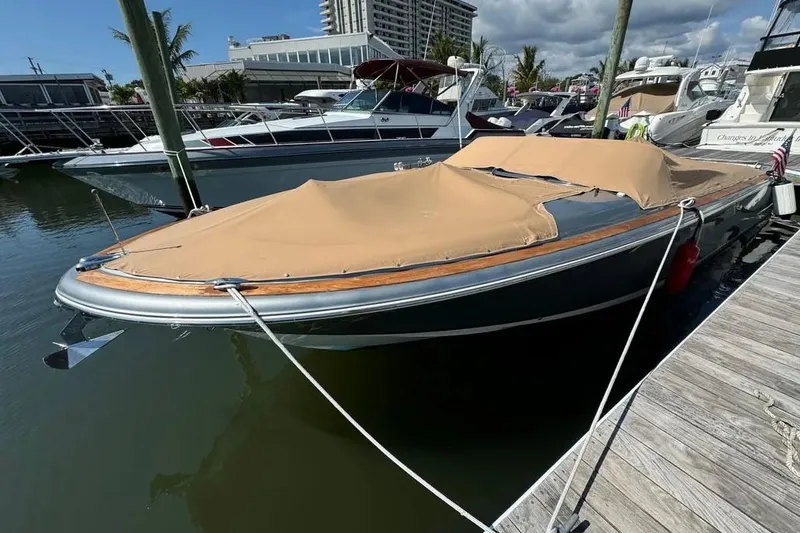 Slide: The Image of 2013 Chris-Craft Launch 32 boat docked with tan cover, marina background. - 23
