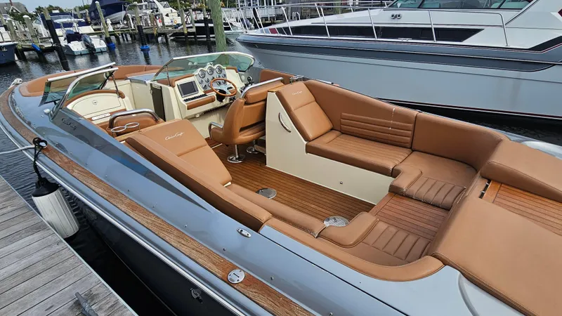 Slide: The Image of 2013 Chris-Craft Launch 32 boat with luxurious tan seating docked at a marina. - 5