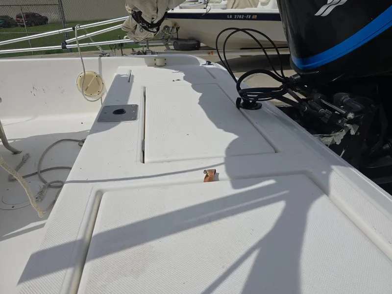 Slide: The Image of 2000 Champion 21 Bay Champ boat deck with motor and storage compartments. - 12