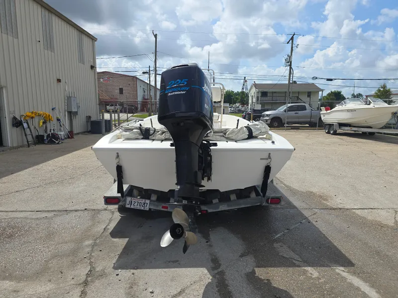 Slide: The Image of Rear view of a 2000 Champion 21 Bay Champ boat with an outboard motor. - 5