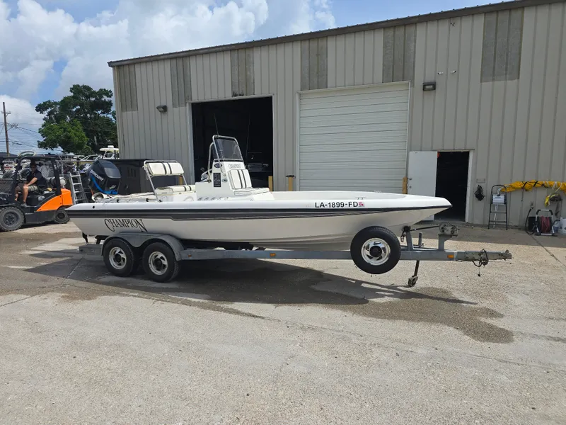 Slide: The Image of 2000 Champion 21 Bay Champ boat on trailer outside a warehouse. - 8