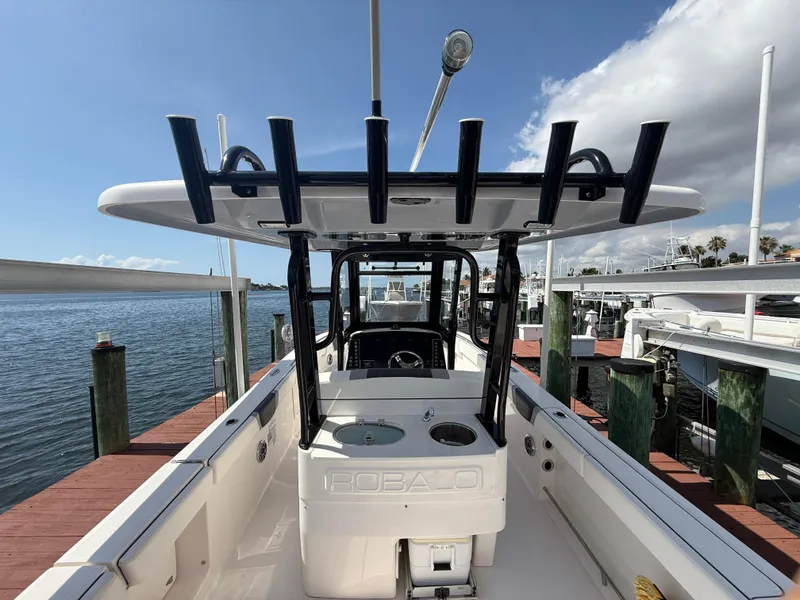 Slide: The Image of 2023 Robalo R272 Center Console boat docked by the water. - 11