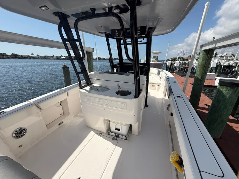 Slide: The Image of 2023 Robalo R272 Center Console boat docked by the water. - 12