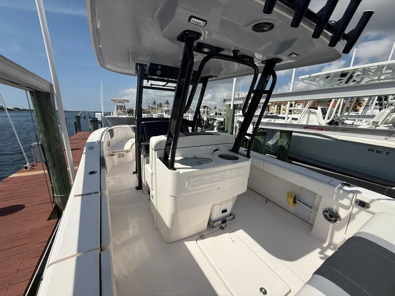 Slide: The Image of 2023 Robalo R272 Center Console boat docked at marina, showcasing spacious deck and seating. - 13