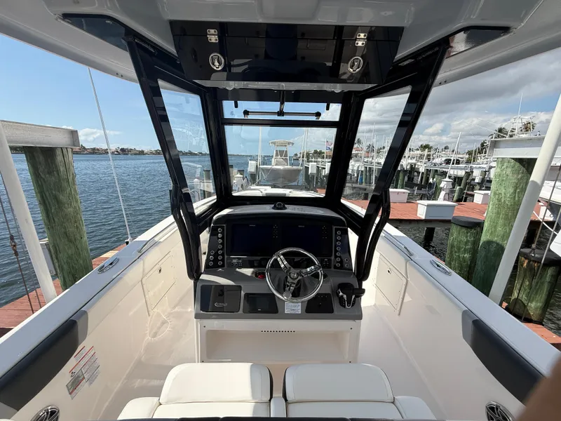 Slide: The Image of 2023 Robalo R272 Center Console boat interior at a marina dock. - 15