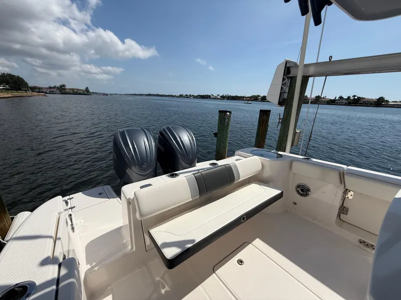 Slide: The Image of 2023 Robalo R272 Center Console boat with dual engines, docked by a scenic waterfront. - 18