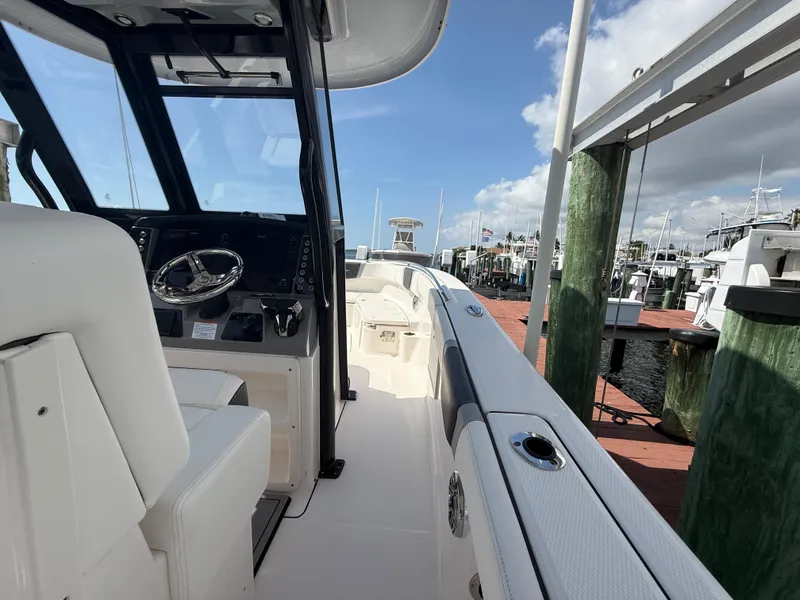 Slide: The Image of 2023 Robalo R272 Center Console boat docked at marina under blue sky. - 22