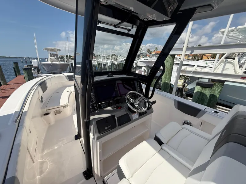 Slide: The Image of 2023 Robalo R272 Center Console boat interior with steering wheel and seating. - 24