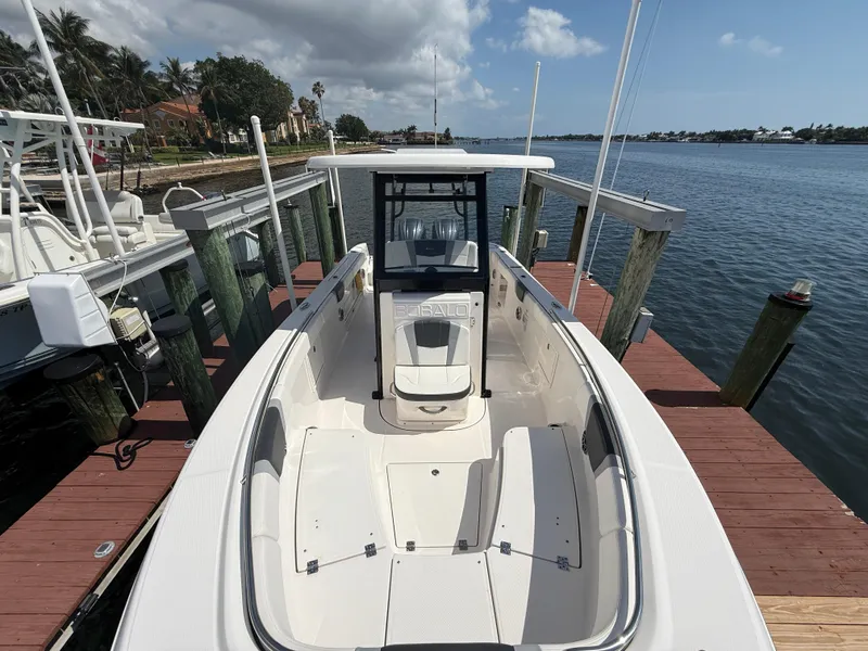 Slide: The Image of 2023 Robalo R272 Center Console boat docked by the water. - 3