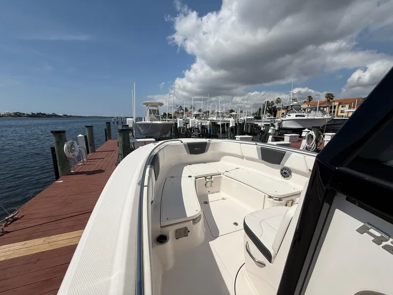 Slide: The Image of 2023 Robalo R272 Center Console boat docked at marina under cloudy sky. - 31