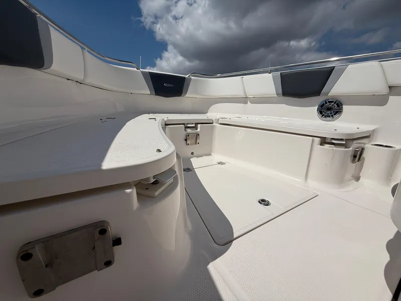 Slide: The Image of 2023 Robalo R272 Center Console boat interior with seating and storage under cloudy sky. - 33