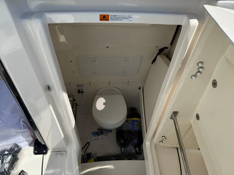 Slide: The Image of 2023 Robalo R272 Center Console boat interior with compact marine toilet. - 36
