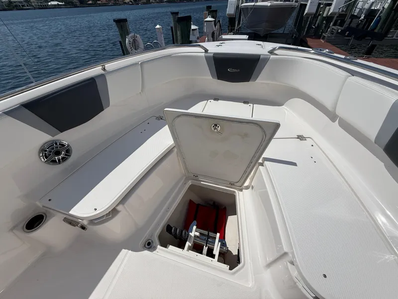 Slide: The Image of 2023 Robalo R272 Center Console boat with open storage compartment, docked by the water. - 37