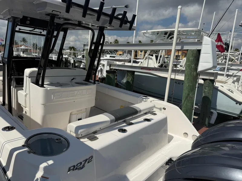 Slide: The Image of 2023 Robalo R272 Center Console boat docked at marina, showcasing sleek design and spacious deck. - 6