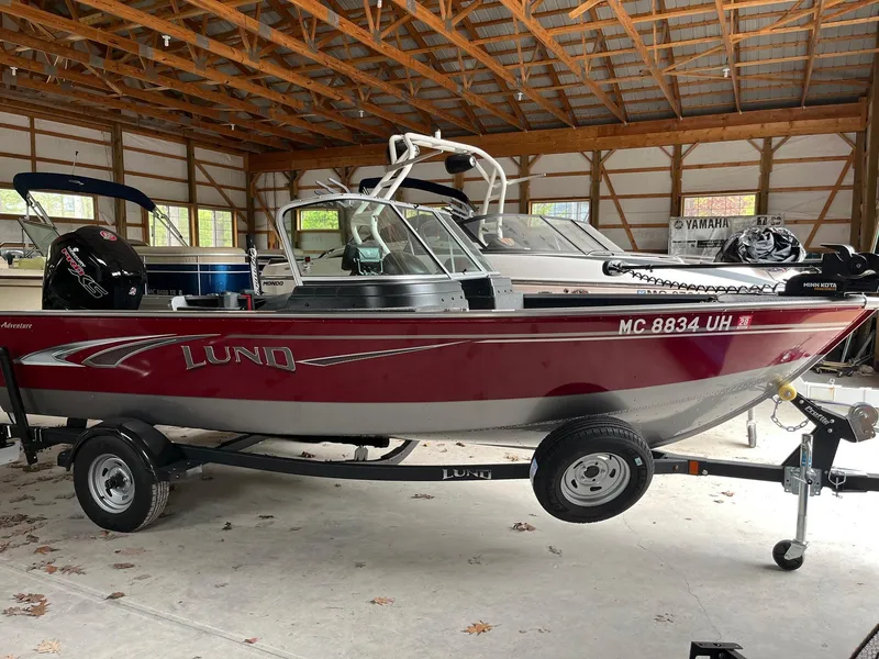 Slide: The Image of 2019 Lund 1775 Adventure Sport boat in a garage, red and silver design. - 11