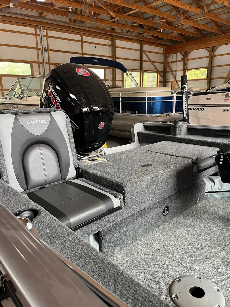 Slide: The Image of 2019 Lund 1775 Adventure Sport boat in storage, featuring a sleek interior and powerful motor. - 6