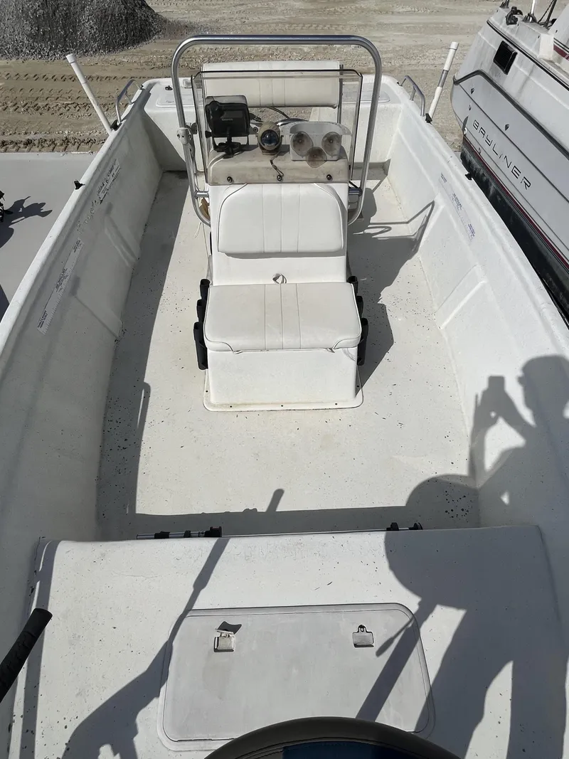 Slide: The Image of 2004 Sea Chaser 1950 Roll Gunnel boat interior with white seating and console. - 3