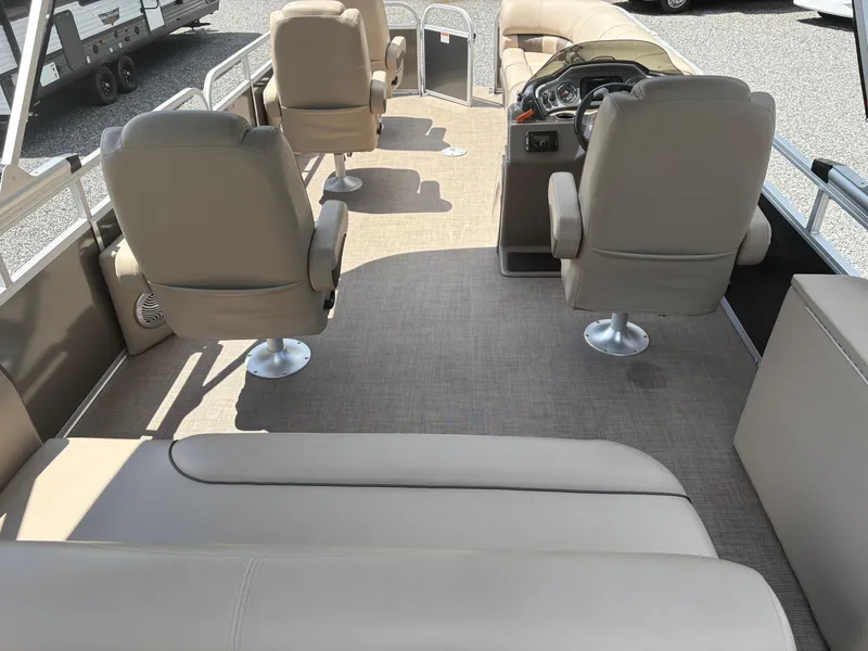 Slide: The Image of 2022 Sun Tracker Party Barge 24 DLX interior with beige seating and steering console. - 22