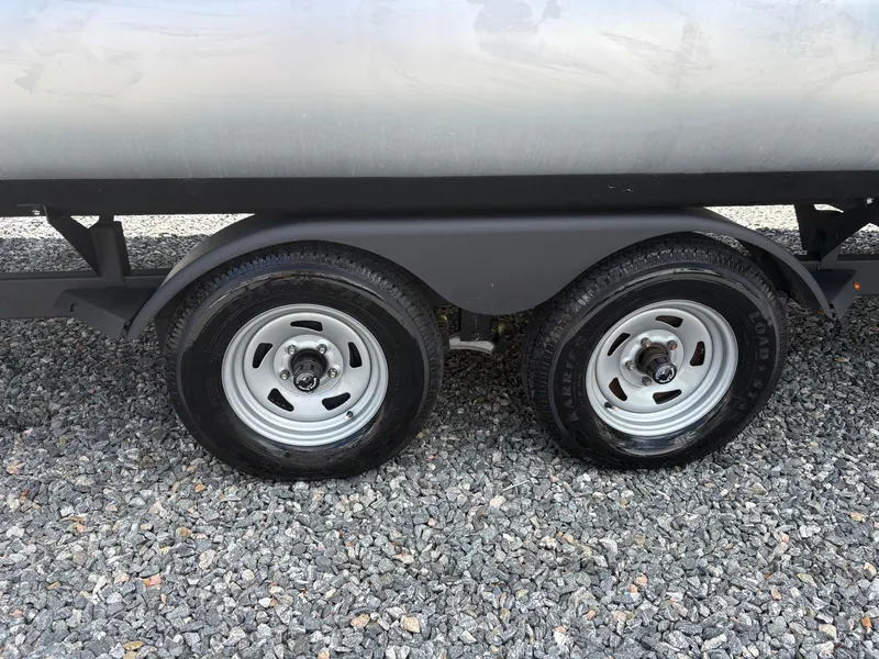 Slide: The Image of Trailer wheels of 2022 Sun Tracker Party Barge 24 DLX on gravel surface. - 23