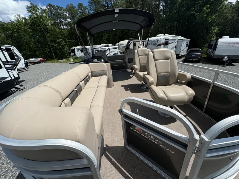 Slide: The Image of 2022 Sun Tracker Party Barge 24 DLX with beige seating, parked outdoors. - 7
