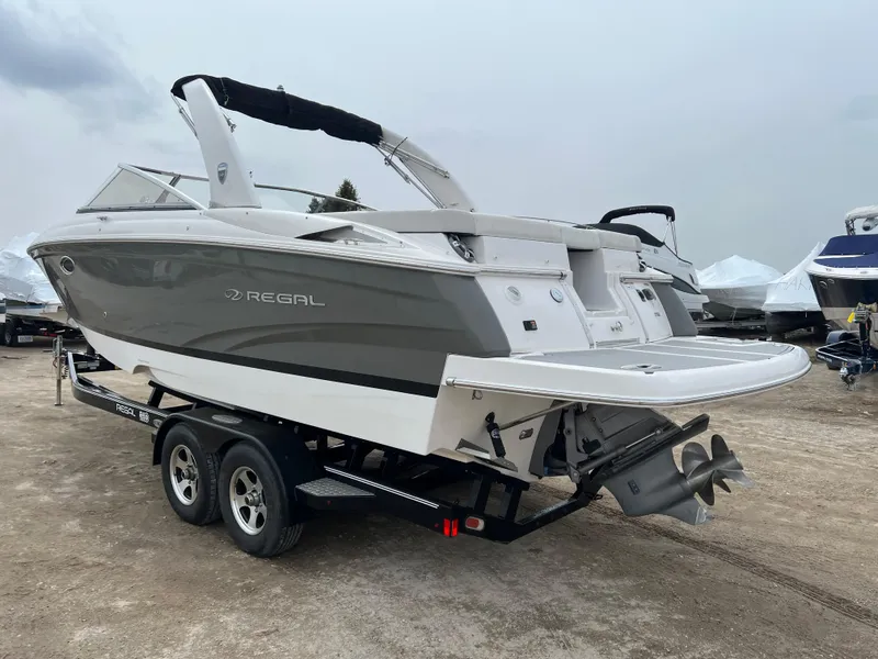 Slide: The Image of 2017 Regal 2700 boat on trailer, gray and white design, parked outdoors. - 11