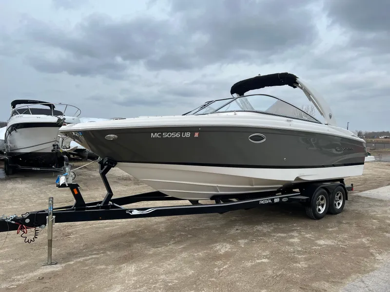 Slide: The Image of 2017 Regal 2700 boat on trailer under cloudy sky. - 2
