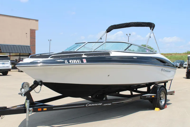 Slide: The Image of 2012 Crownline 21 SS boat on trailer, parked outdoors under clear sky. - 1