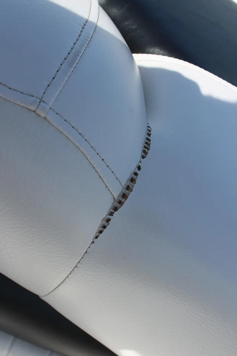 Slide: The Image of Close-up of a 2012 Crownline 21 SS boat seat with visible stitching and tear. - 17
