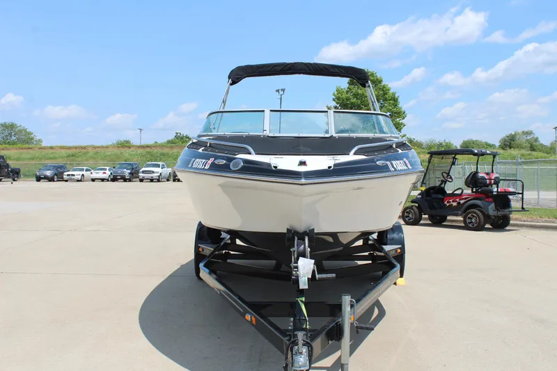 Slide: The Image of 2012 Crownline 21 SS boat on trailer, parked outdoors under a clear sky. - 2