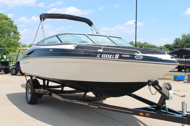 Slide: The Image of 2012 Crownline 21 SS boat on trailer, parked outdoors under a clear sky. - 3