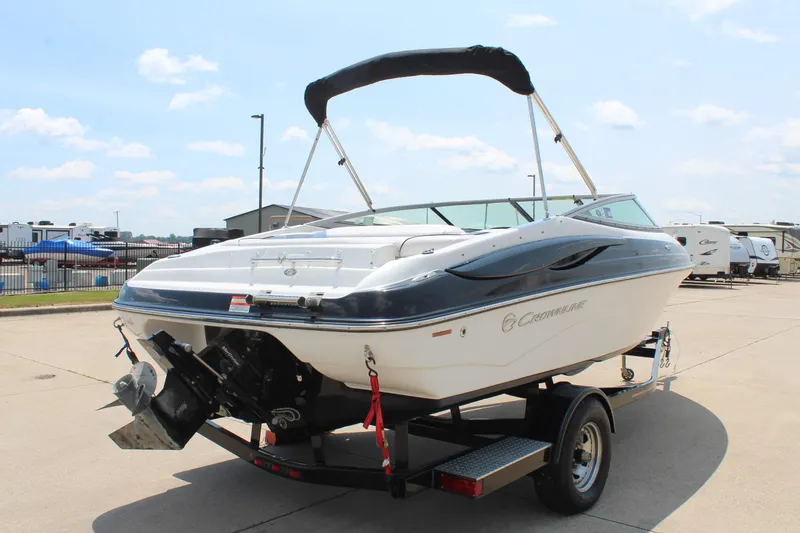 Slide: The Image of 2012 Crownline 21 SS boat on trailer, parked outdoors under a clear sky. - 5