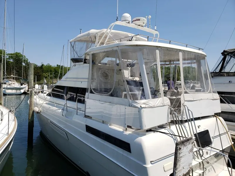 Slide: The Image of 1993 Silverton 41 Aft Cabin yacht docked in a marina under clear blue skies. - 1