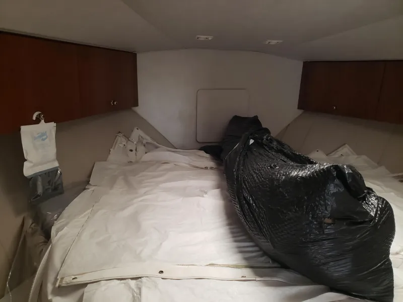 Slide: The Image of 1993 Silverton 41 Aft Cabin interior with bed, storage cabinets, and wrapped items. - 11